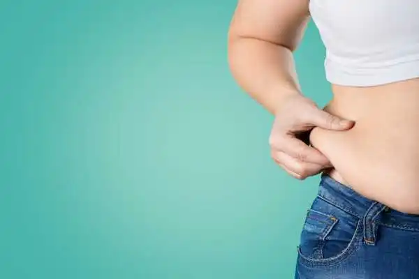 Image of woman pinching her love handles to show weight gain Weston Super Mare